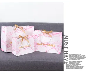 Roze marmer patroon papier cadeautas met goud lint, perfect voor bruiloft en detailhandel.