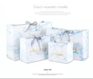 Blauwe marmeren papieren cadeautasjes met linten en handvatten voor feesten en geschenken.