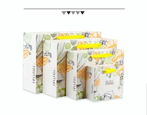 Set of stylish paper gift bags with fresh fruit sketches and yellow ribbon handles.