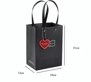 Bolsa de regalo de papel negro con asas y etiqueta de corazón para fiestas y compras.