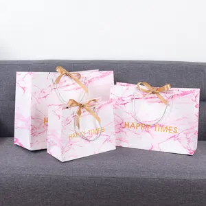 Roze marmeren cadeau papieren zakken met gouden lint handvatten voor winkels en feesten.