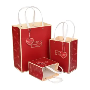 Bolsas de regalo de papel rojo de alta calidad con asas de cinta y etiquetas de corazón para fiestas.