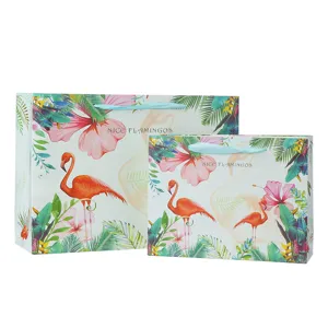 Tropical flamingo paper gift bag detail shot, elegant floral design with ribbon handle.