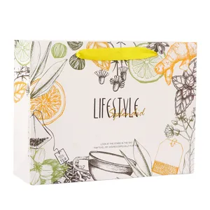 Botanical design paper shopping bag with yellow ribbon handles for gift packaging and tea.