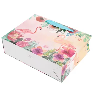 Roze flamingo papieren cadeauzakje met blauwe lint handvatten, ideaal voor feestjes en winkelen.