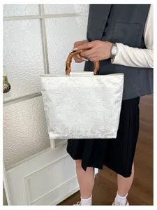 Sac cabas en tissu blanc avec poignée en bambou, design jacquard floral élégant pour le bureau.