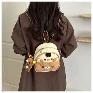 Detail view of cute cartoon bear style mini backpack with lovely embroidered design and plush pendant.