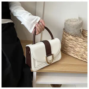 Primo piano dettagliato dell'elegante borsa bicolore in pelle PU con fibbia in metallo.