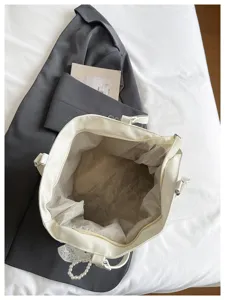 Vista dettagliata dell'interno della borsa bianca con fodera e pratica chiusura con zip.