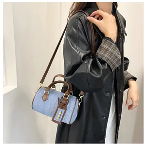 Vintage denim Boston handbag for women, stylish cross-body shoulder bag with brown leather trim.