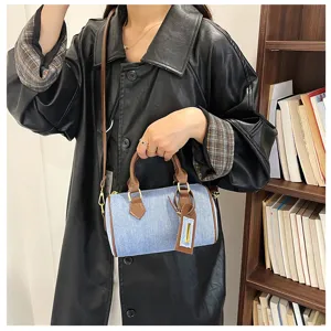 Vintage denim Boston handbag detail shot, casual shoulder crossbody bag with brown leather trim.