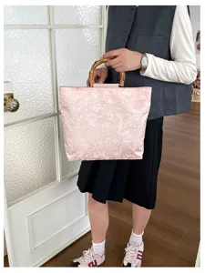 Sac cabas rose en toile avec poignée en bambou et jacquard floral pour le travail.