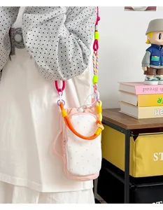 Charming pink polka dot crossbody bag with colorful rope straps, perfect for outdoor use.