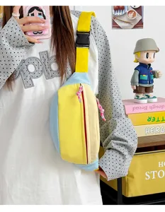 Color-block chest bag detail showing vibrant yellow, blue and beige canvas design with strap.