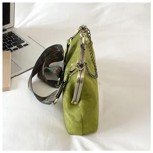 Detailed view of a vintage green suede kiss lock shoulder bag with chain and strap.