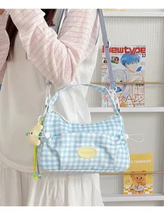 Blue and white checkered shoulder bag detail showing cute pendant and front pocket design.