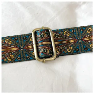 Close-up detail of vintage ethnic pattern fabric bag strap with bronze metal adjustable slider.