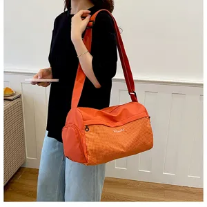 Compact orange travel duffel bag for gym, fitness, and short weekend trips with comfortable strap.