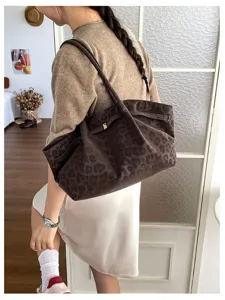 Vista dettagliata di una borsa a spalla morbida in pelle con stampa leopardo chic.