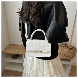 Détail de sac bandoulière texturé blanc, élégant sac carré avec poignée et lanière.