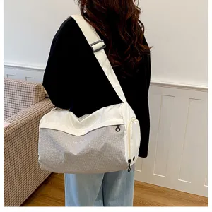 Detail view of a lightweight casual travel duffel bag with wide strap and side pocket.