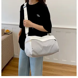 Detail view of the casual travel duffel bag worn by model, showing fabric and strap.