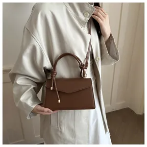 Stylish brown leather top-handle shoulder bag with chic knot detail for women daily wear.