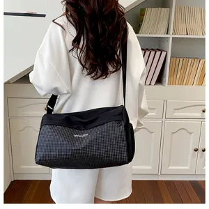 Detailed showcase of the lightweight black grid travel shoulder bag in neat room decor.
