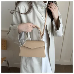 Elegant beige shoulder bag detail, featuring a chic knotted handle and durable PU leather.