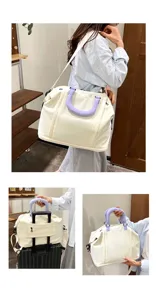 Vue détaillée du grand sac de voyage avec poignées violettes et sangle de valise.