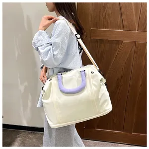 Detailed view of the large capacity canvas travel bag showing the durable purple handle and strap.