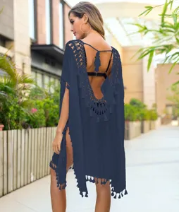 Detail view of backless beach cover-up featuring delicate crochet lace and tassel hem.