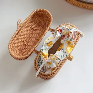 Handmade woven rattan straw crossbody bag with beautiful floral drawstring lining detail.
