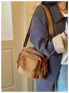 Vue détaillée du sac bandoulière marron décontracté avec plusieurs poches et sangle.
