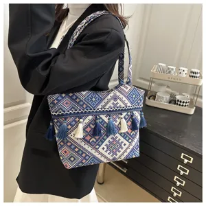 Detailed shot of retro ethnic style woven canvas tote bag with tassels in a stylish scene.