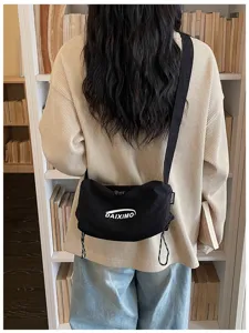 Vista dettagliata di una borsa a tracolla nera in nylon con cinghia regolabile e stile casual.