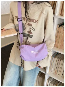 Dettaglio borsa tracolla a sacco in nylon viola chiaro, stile casual minimalista.