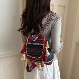 Retro ethnic style small women backpack with geometric woven straps and delicate tassel charms.
