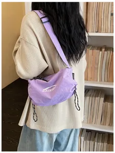 Vista dettagliata di una borsa a tracolla casual in nylon viola con coulisse e logo stampato.