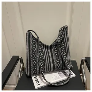Black and white woven hobo shoulder bag with geometric ethnic pattern and wide strap.