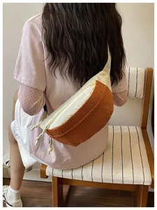 Detail view of stylish two-tone crossbody bag with corduroy texture and zipper closure.