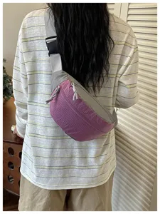 Detailed scene view of the color-blocked crossbody bag worn on back, showing strap and texture.