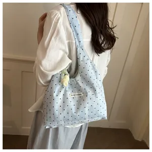 Korean style cute polka dot fabric shoulder bag detail showing soft texture and cute tag.