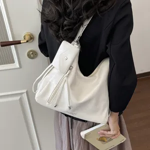 Vista dettagliata di questa elegante borsa a sacco bianca con tasca laterale e nappe.