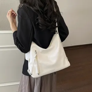 Vista dettagliata di una borsa a spalla minimalista bianca con tasche frontali con zip.