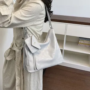 Vista di dettaglio di una borsa a tracolla casual minimalista con piccola tasca e pelle morbida.