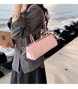 Detail view of the elegant pink shoulder bag featuring charming star print and side bow accents.