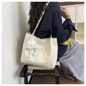 Vista dettagliata della borsa tote in tela bianca con stelle e ciondolo a nuvola.