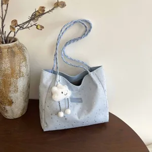 Borsa tote blu chiaro con stampa di stelle, manici intrecciati e ciondolo peluche nuvola.
