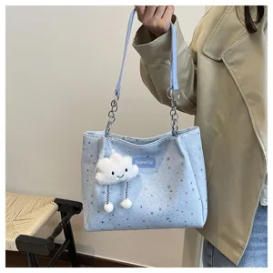 Detail view of the light blue shoulder bag with star pattern, chain strap, and cloud pendant.